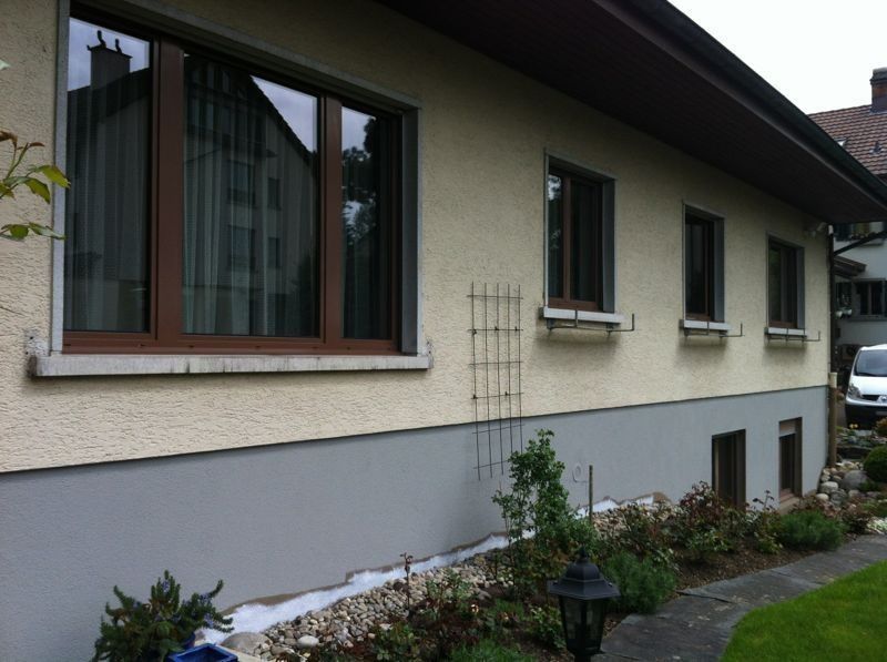 Hausfassade nach dem Anstrich mit dunklem Sockel