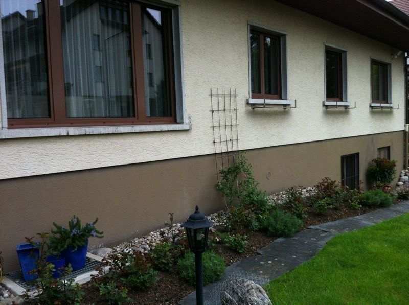 Hausfassade vor dem Anstrich mit hellem Sockel