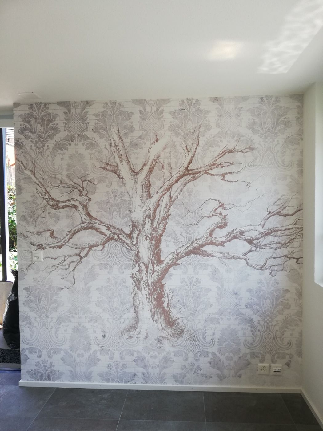 Wand mit gemaltem Baum in hellen Farbtönen