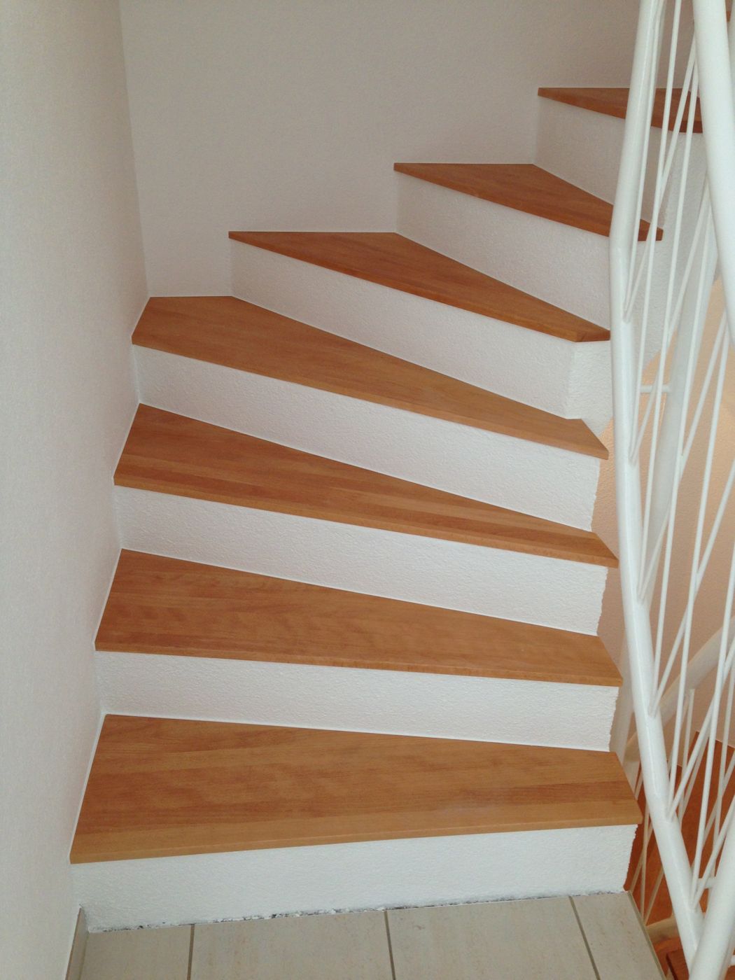 Treppe mit weiss gestrichenen Wänden und Holzstufen