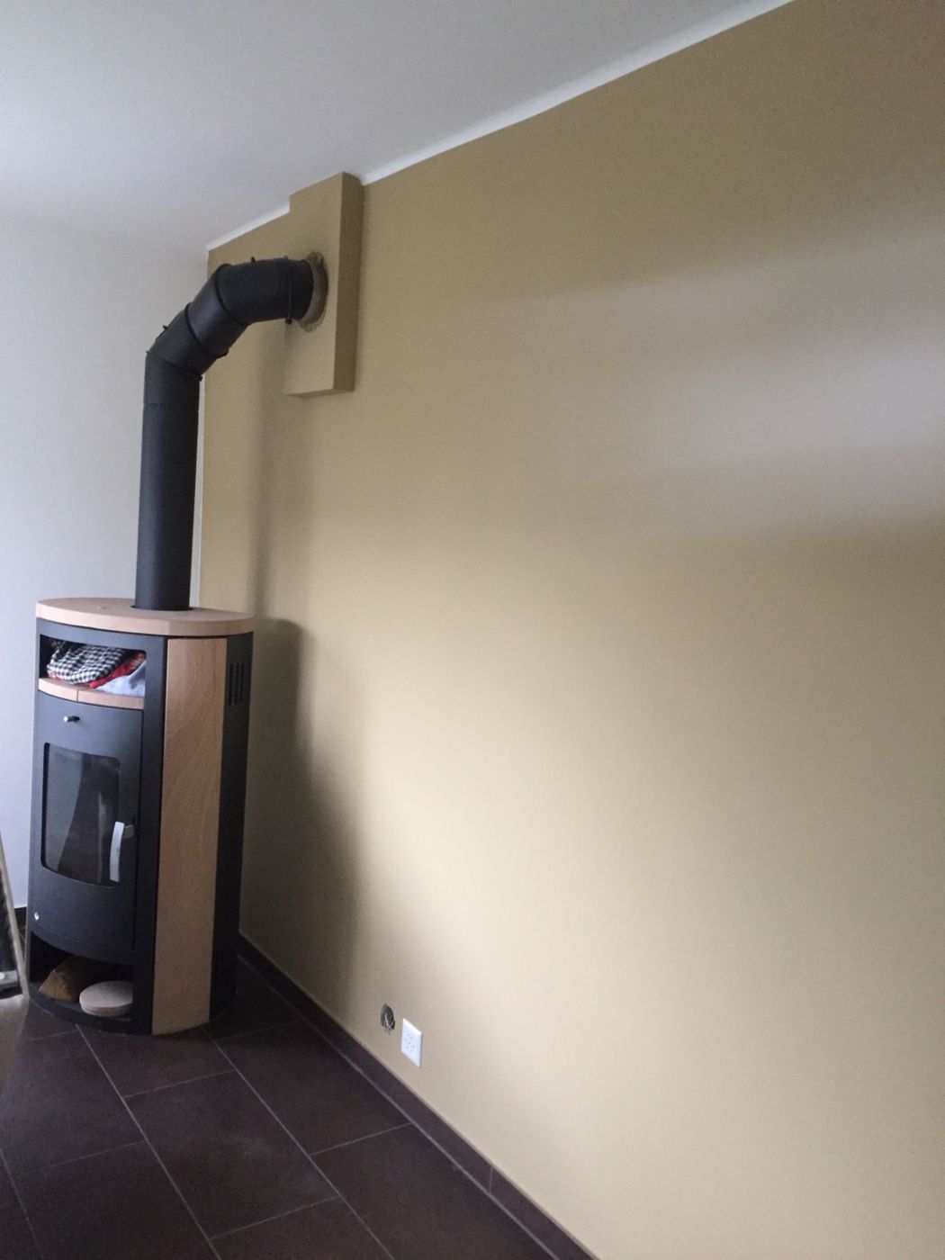 Wohnraum in warmem Beige mit Kaminofen